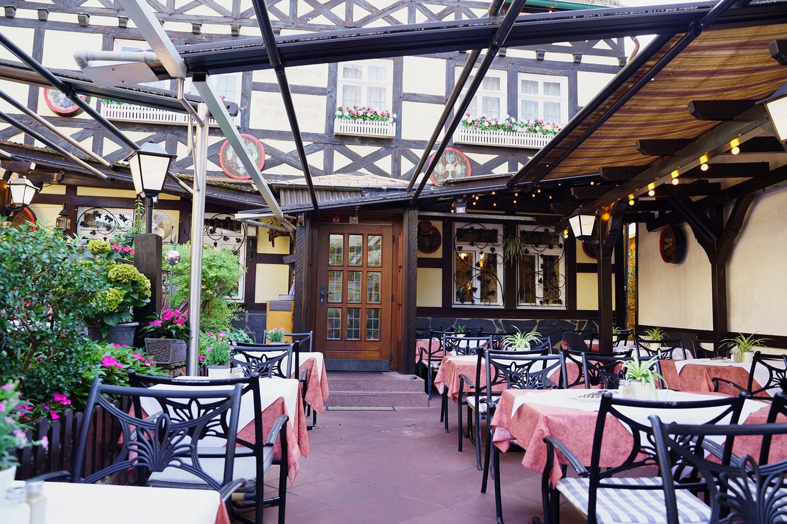 Blick zur Tür des Restaurants mit Sitzplätzen auf der Terrasse im Vordergrund