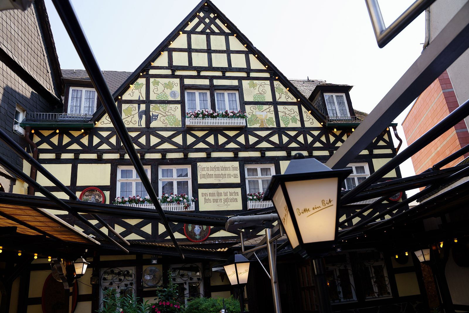 Blick auf die Fachwerkfassade mit Rankmalerei über der Terrasse