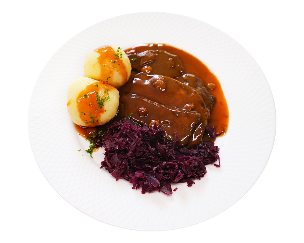 Rheingauer Sauerbraten mit Rotkohl und Klößen Sauerbraten mit Rotkohl und Kartoffelklößen auf weißem Teller angerichtet